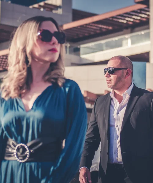 Mujer escoltada por un agente de seguridad en una zona comercial exclusiva.