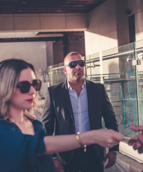 Agente de seguridad privada brindando protección a una persona VIP en un centro comercial.